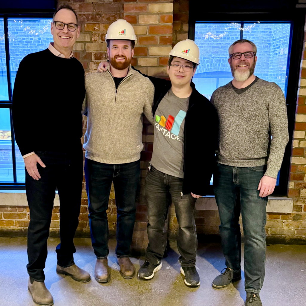 Vantage employees wearing hard hats recognized as Hard Hat Award winners during company hackathon dinner